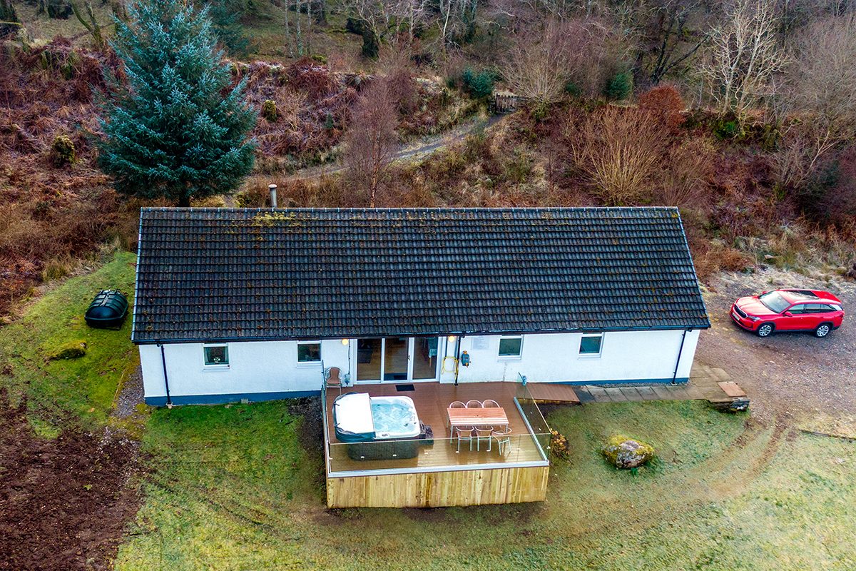 The cottage from above with the decking and hot tub